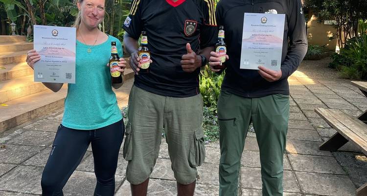 Three people holding certificates and drinks, smiling at the camera.