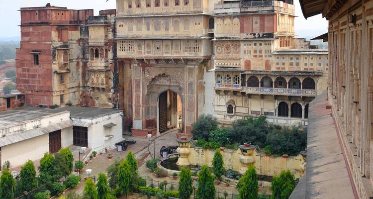 Een uitgebreid historisch paleis met gedetailleerde architectuur en een tuin ervoor.