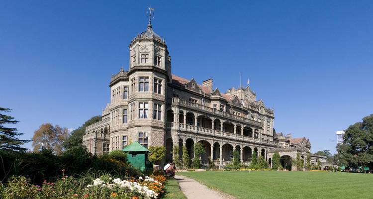 Een groots stenen gebouw met ingewikkeld ontwerp tegen een heldere blauwe lucht.