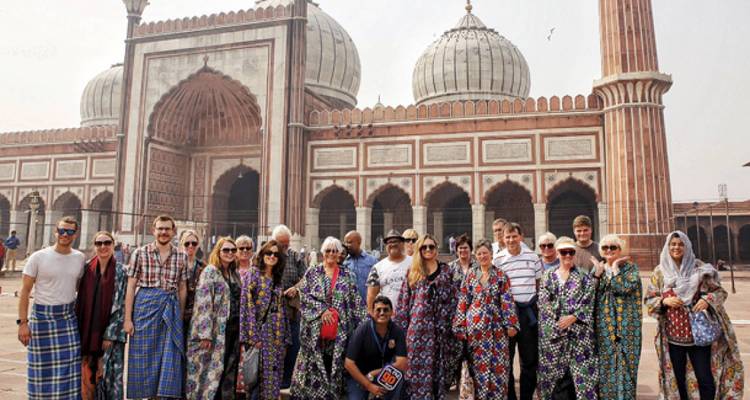 Een groep toeristen die poseert voor een oude moskee.