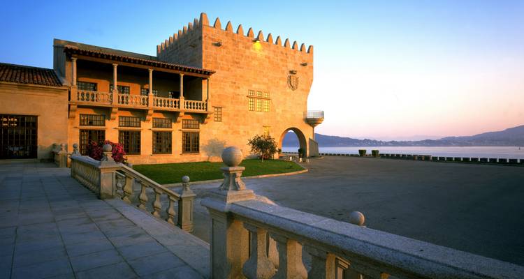 Bâtiment historique au bord de l'eau au crépuscule.