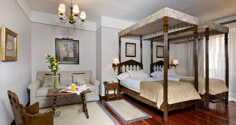 Chambre d'hôtel luxueuse avec lits jumeaux et décor classique.