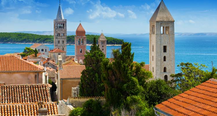 Tours historiques surplombant la mer avec une végétation luxuriante.
