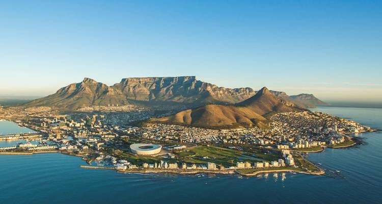 Vue aérienne d'une ville côtière avec une montagne emblématique en forme de table.