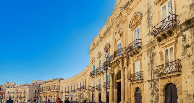 Élégante rue courbe de palais en calcaire et de balcons sur l'île d'Ortigia, Syracuse.
