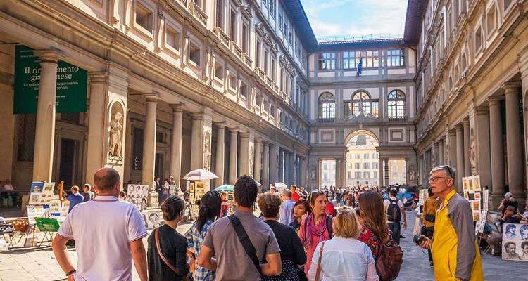 Menigten toeristen verzamelden zich tussen de gezuilde vleugels van de Uffizi-galerij in Florence op een zonnige dag.