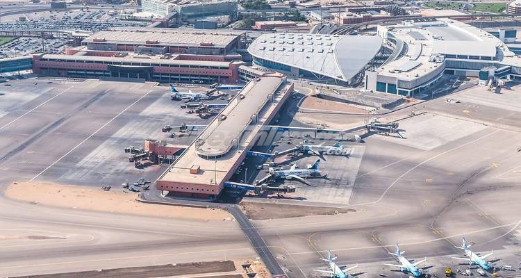 Luchtfoto van een luchthavencomplex met start- en landingsbanen en vliegtuigen.