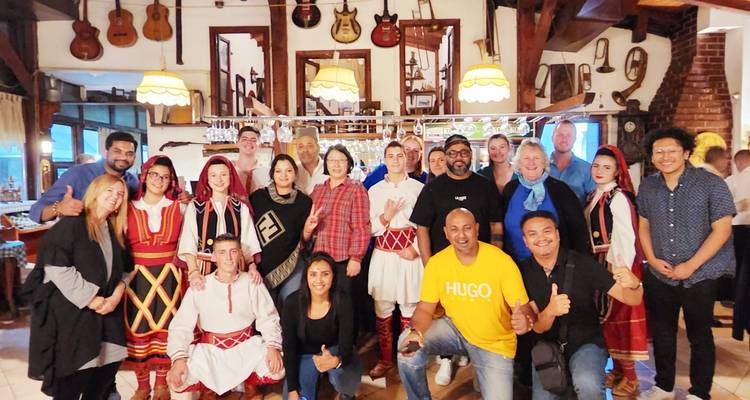 Gruppe von Menschen in traditioneller Kleidung, die in einem Restaurant posieren.