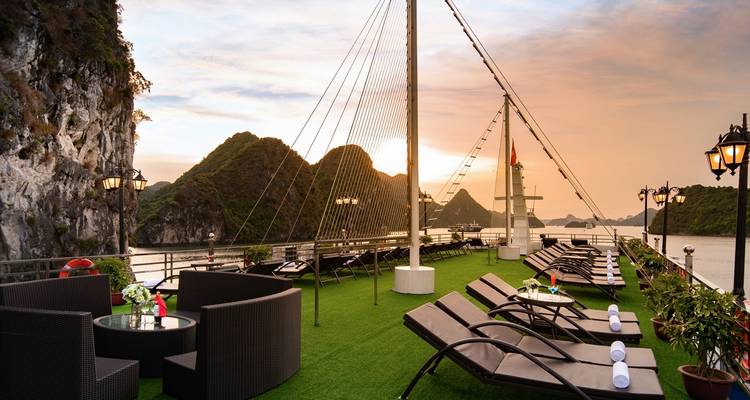 Luxuriöses Kreuzfahrtdeck mit Liegestühlen und Blick auf die Bucht.