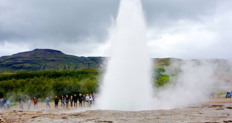 Observation de la foule au geyser Strokkur en éruption au milieu d'une vapeur abondante par un jour nuageux