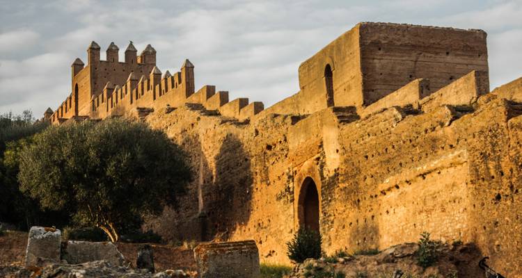 Chellah ruins with stone walls at sunset.