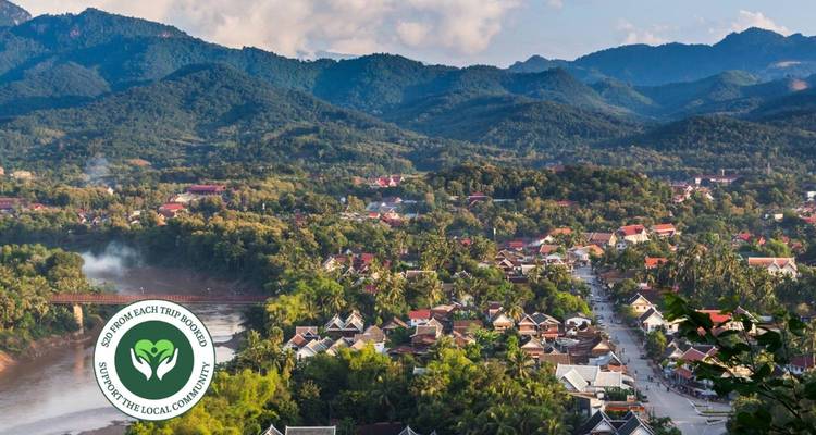 Panoramisch uitzicht op een stad omringd door weelderige heuvels.
