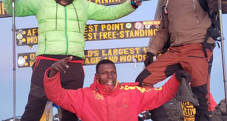 Groupe de personnes célébrant au sommet avec des pancartes