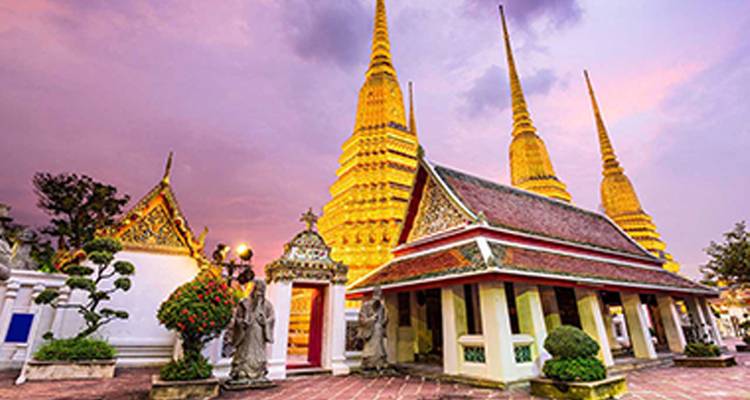 Ornately decorated temple with golden stupas and dramatic lighting.
