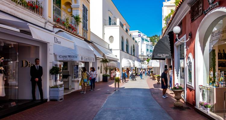 Upscale pedestrian shopping lane in Capri lined with luxury boutiques and tourists.
