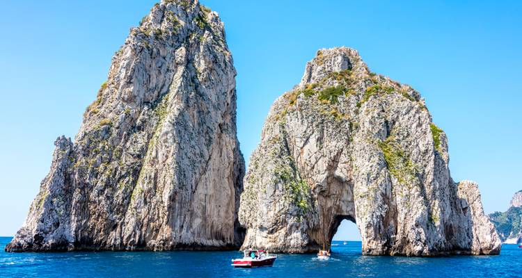 Famous Faraglioni sea stacks off Capri rising steeply from the blue Mediterranean.