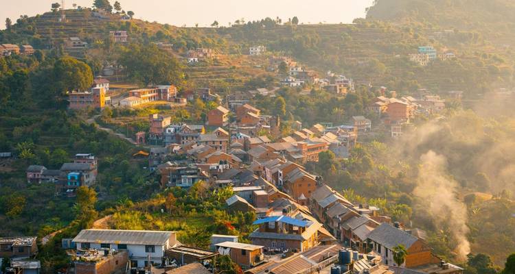 Dorpslandschap met terrasvormige heuvels and huizen.