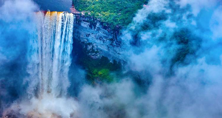Cascada cayendo por un acantilado rodeada de niebla.