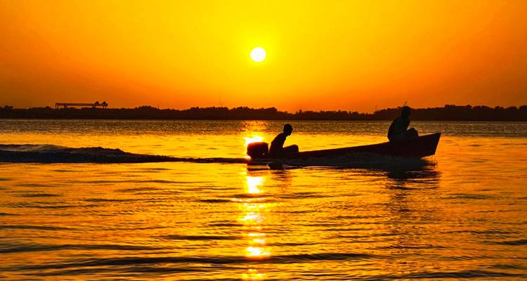 Barco en el agua durante una puesta de sol.