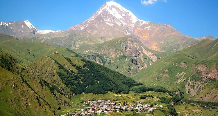 Vue majestueuse de montagne avec un village en contrebas.