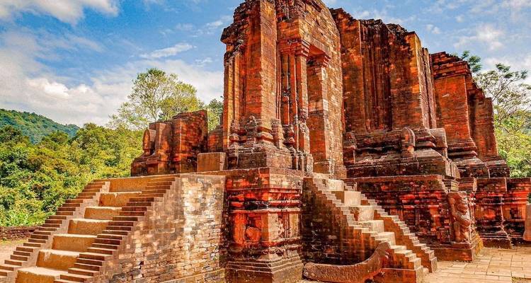 Oude rode bakstenen tempelruïnes onder een blauwe hemel.