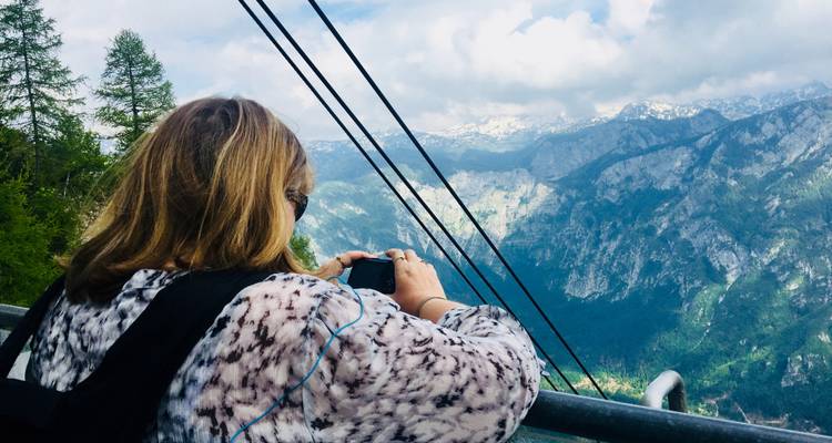 Person taking a photo of a mountainous landscape.