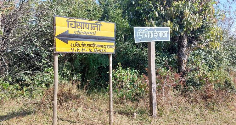 Señal indicadora que muestra una dirección tanto en inglés como en escritura local.