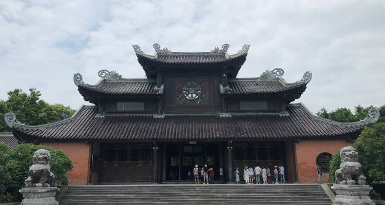 Traditioneller Tempel mit kunstvollen Schnitzereien und Touristen, die ihn bewundern.