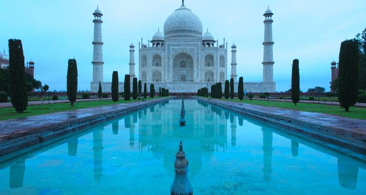 Le Taj Mahal avec son reflet dans l'eau pendant une journée nuageuse.