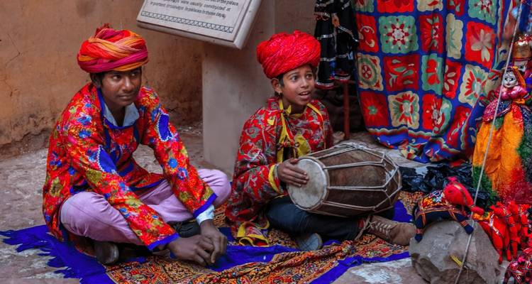 Deux personnes en tenue colorée jouant de la musique traditionnelle.