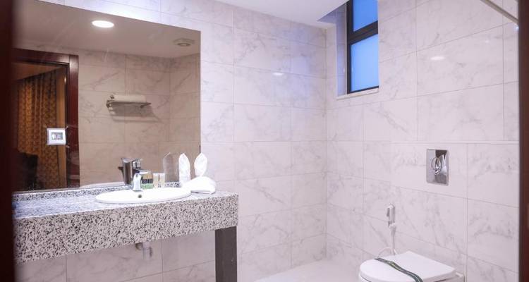 Marmeren betegelde badkamer met moderne voorzieningen.