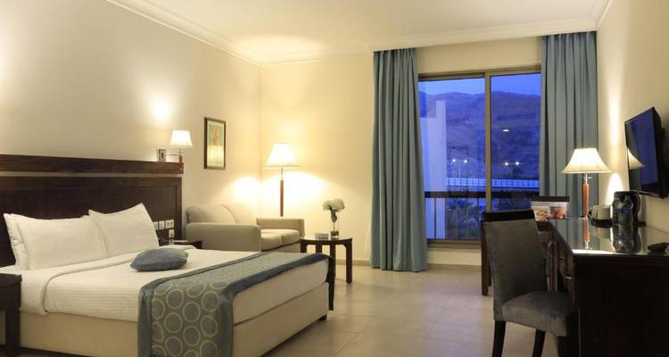 Ruime hotelkamer met een groot bed en uitzicht door het raam.