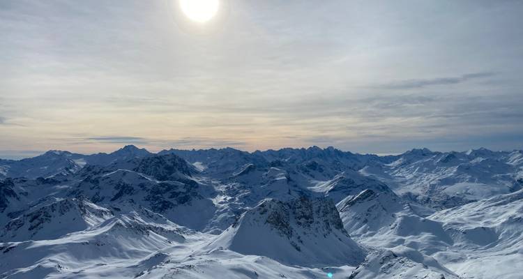 Vue panoramique des sommets enneigés sous le soleil.
