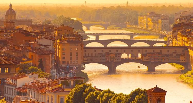 Zicht op Florence met Ponte Vecchio bij zonsondergang, met de rivier de Arno.