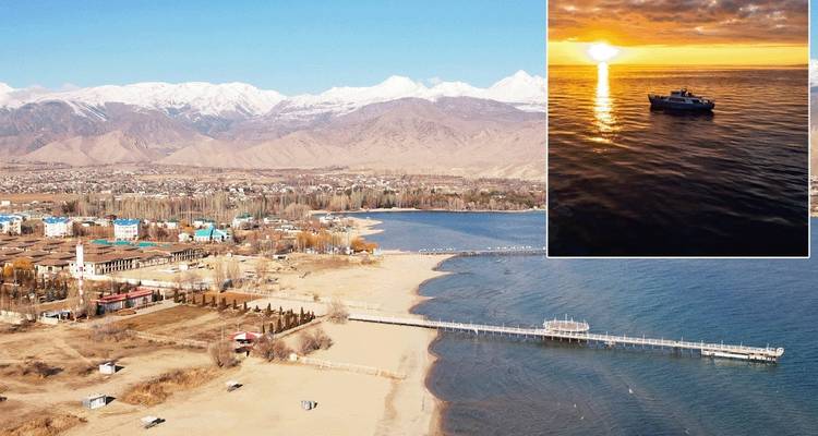 Coastal town with mountains and a sunset over water in the inset.