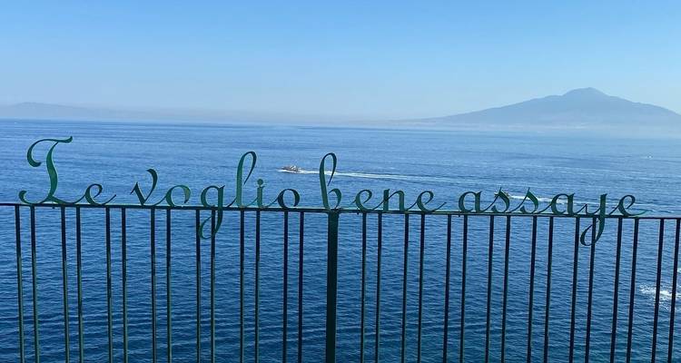 Blick auf die Uferpromenade mit einem Schild mit der Aufschrift 'Te voglio bene assaje' und dem Vesuv.