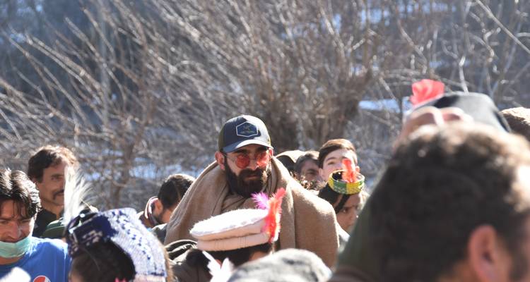 Nahaufnahme einer Gruppe von Menschen in traditioneller Kleidung im Freien.