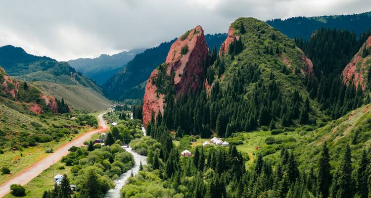 Vue aérienne spectaculaire des falaises de grès rouge et des vallées luxuriantes couvertes de pins de Jeti-Oguz au Kirghizistan