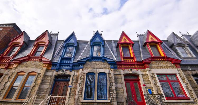Row of colorful historic houses under a partly cloudy sky.