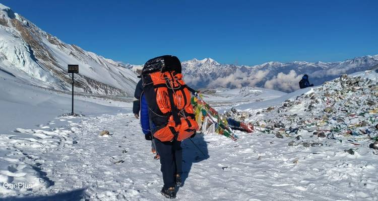 Wanderer, die entlang eines verschneiten Pfades gehen, mit einem Berg im Hintergrund.