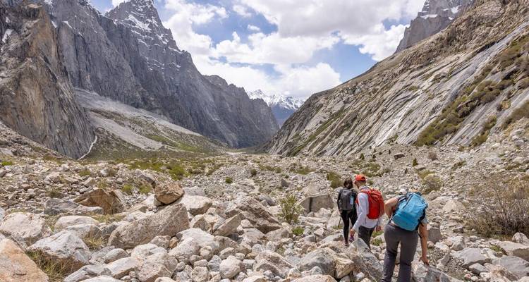 Des randonneurs descendant à travers une vallée rocheuse.