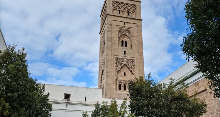 Minaret of a mosque surrounded by trees.