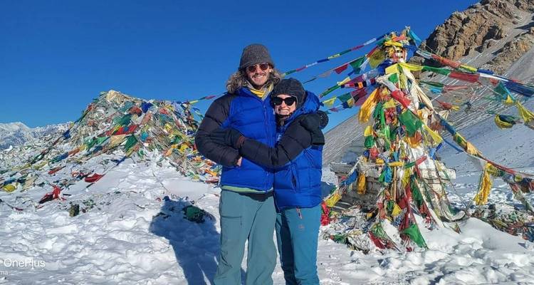 Stel staand tussen gebedsvlaggen met bergen en een watermerk zichtbaar
