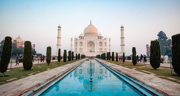 Vue du soir du Taj Mahal avec reflet dans le bassin d'eau bleue.