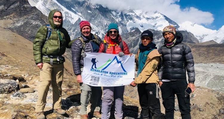 Wandelaars die een spandoek vasthouden met bergen op de achtergrond.