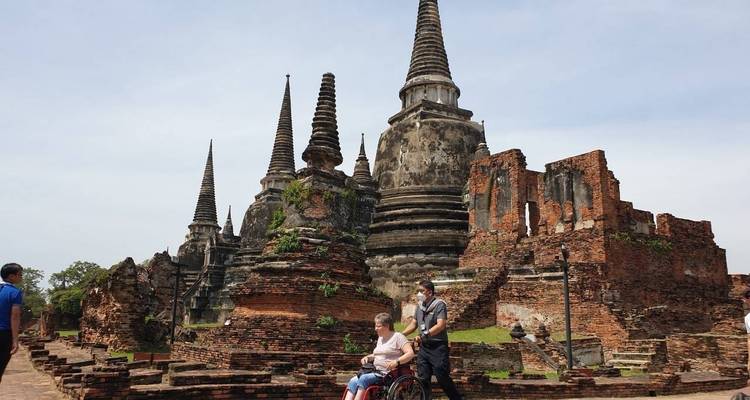 Historic stone temple ruins with people visiting.