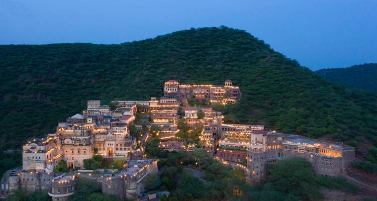 Luftaufnahme eines beleuchteten Festungskomplexes in der Dämmerung.