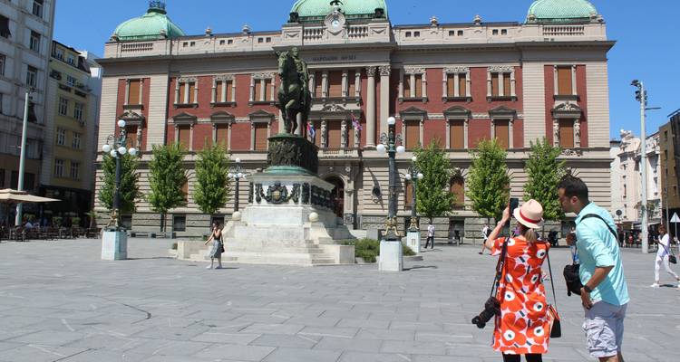 Edificio histórico con una gran estatua ecuestre en una plaza de la ciudad.