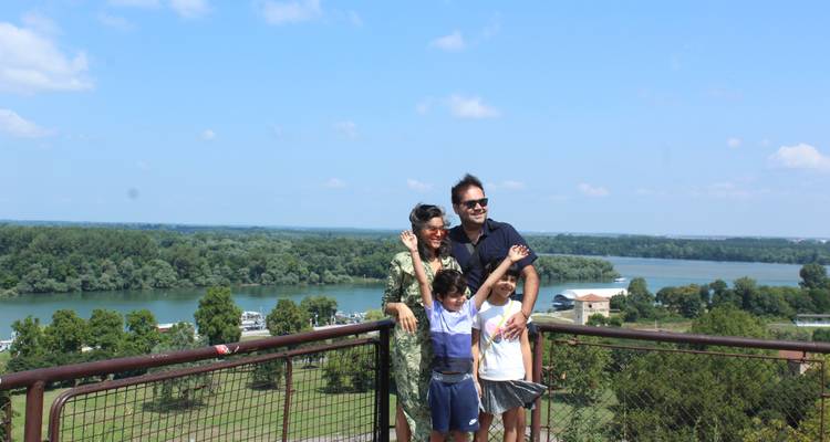 Familia posando en un mirador escénico con vista al agua y las colinas.