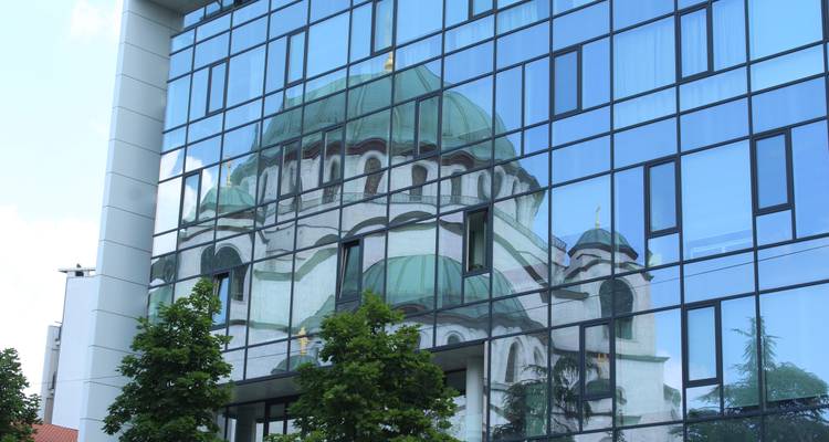 Reflejo de una cúpula en un edificio moderno de cristal.